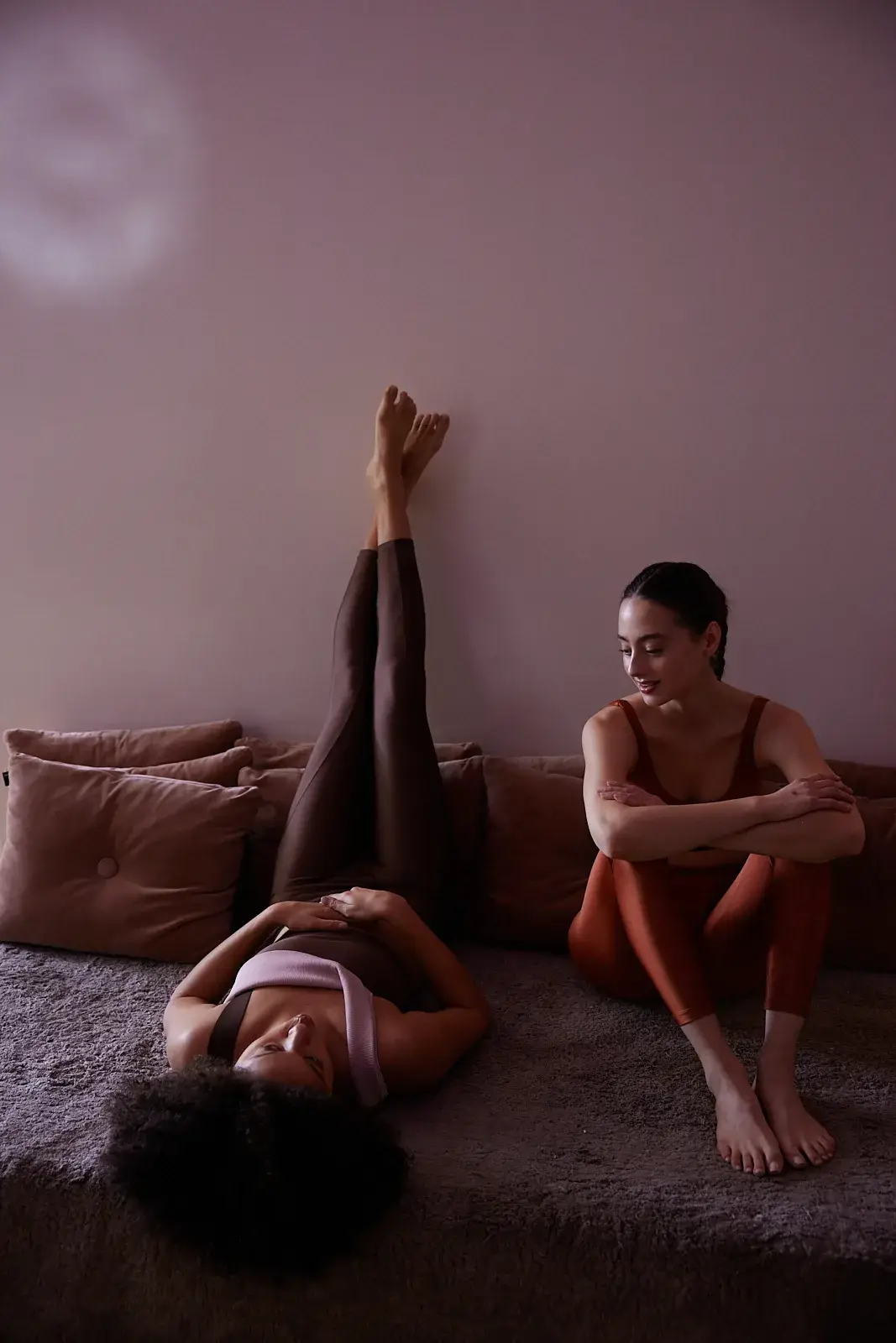 New York Pilates: Women stretch on mats in a studio lounge.