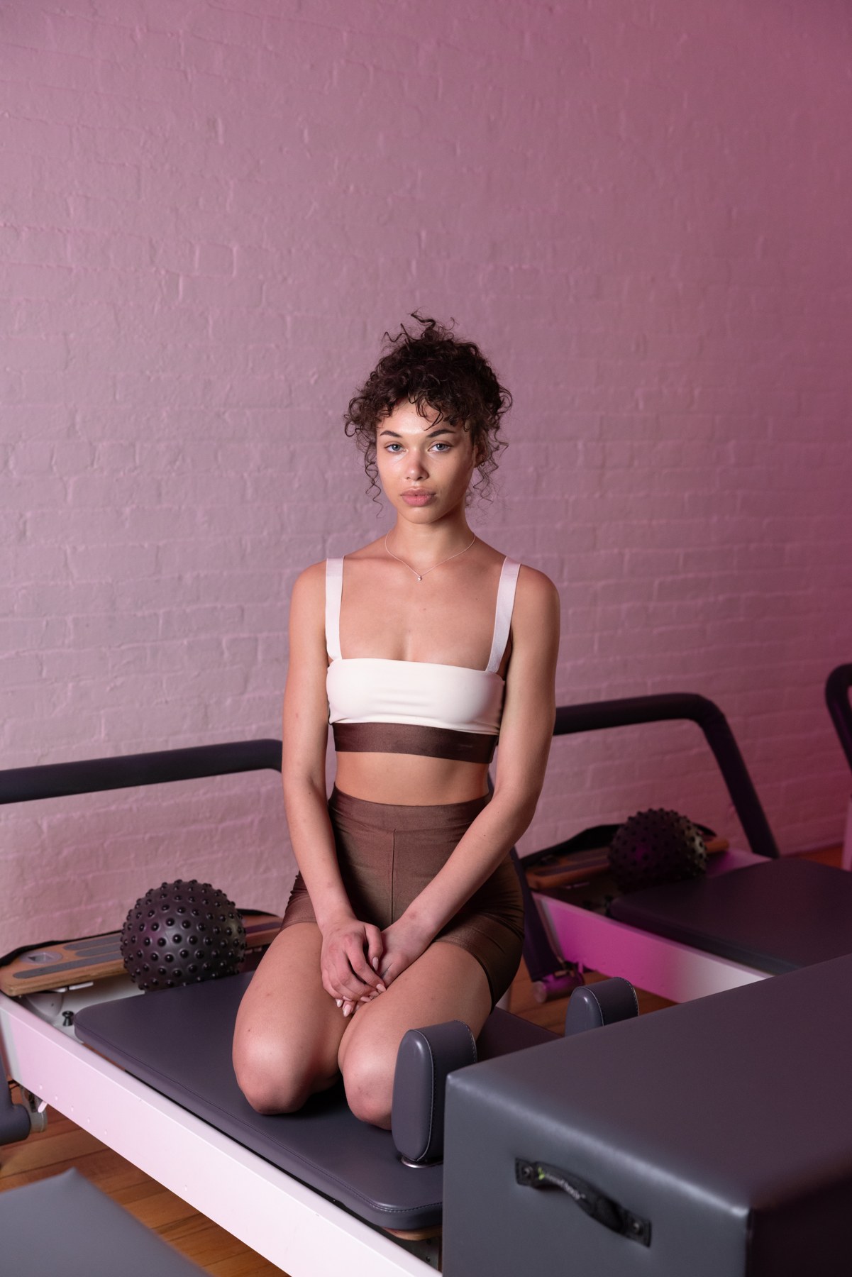 A person kneeling on a reformer in the 2026 New York Pilates West Village shoot