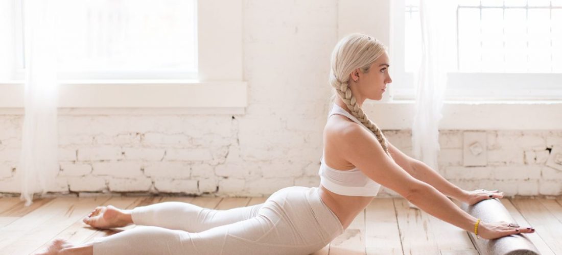 a-woman-stretching-with-a-foam-roller